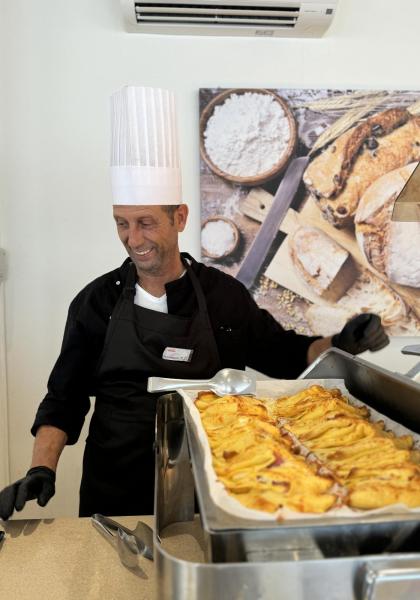 Chef con cappello serve dolci appena sfornati.