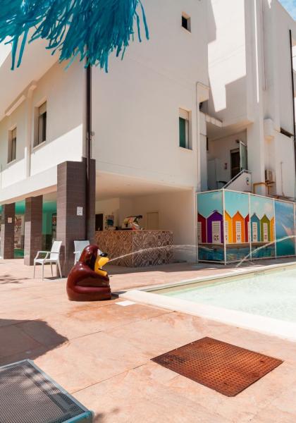 Piscina per bambini con giochi colorati e lettini al sole.