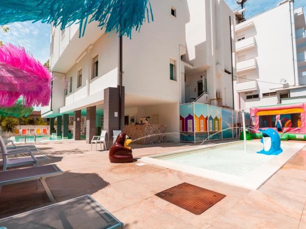 Piscina all'aperto con decorazioni colorate e giochi per bambini.