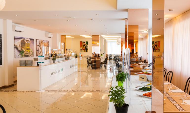 Bright restaurant with buffet and set tables.