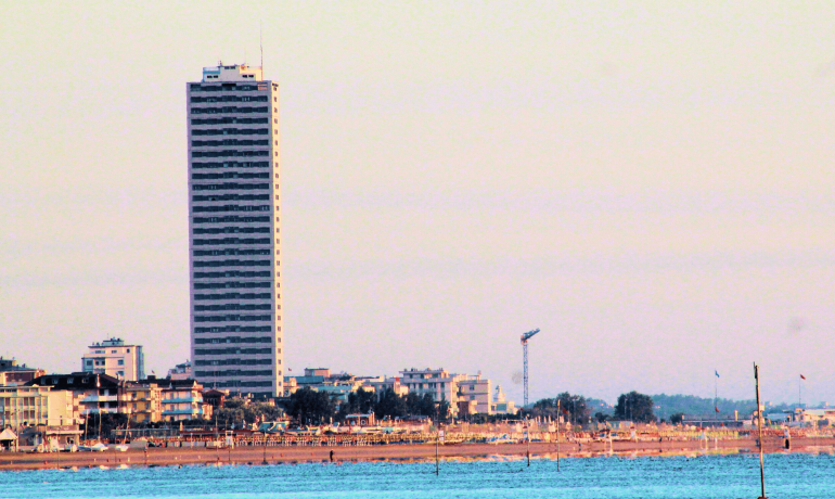 Grattacielo sul lungomare con vista sul mare al tramonto.