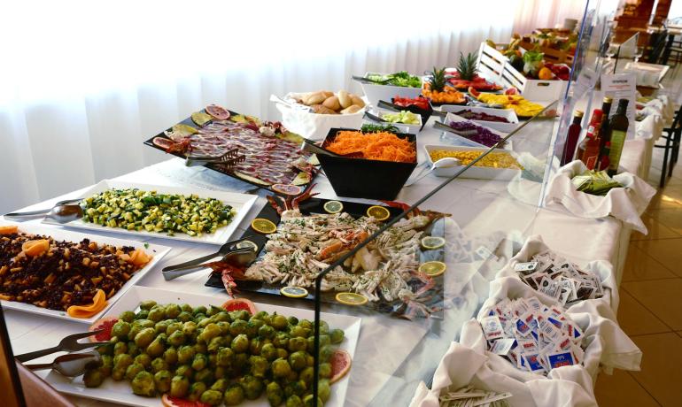 Buffet with vegetables, seafood, and various condiments.