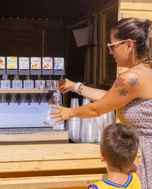 Woman fills water bottle at a vending machine.