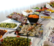 Buffet ricco di verdure, salumi e salse su un tavolo elegante.
