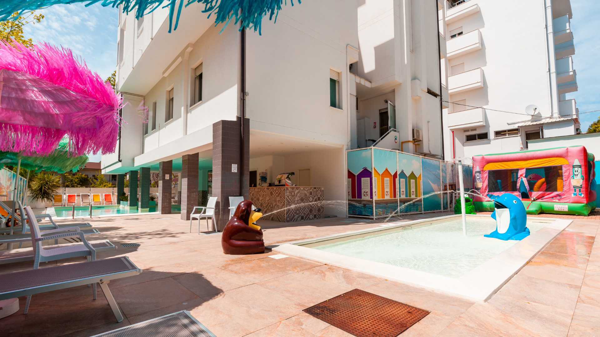 Piscina per bambini con giochi e gonfiabili in un ambiente colorato e divertente.