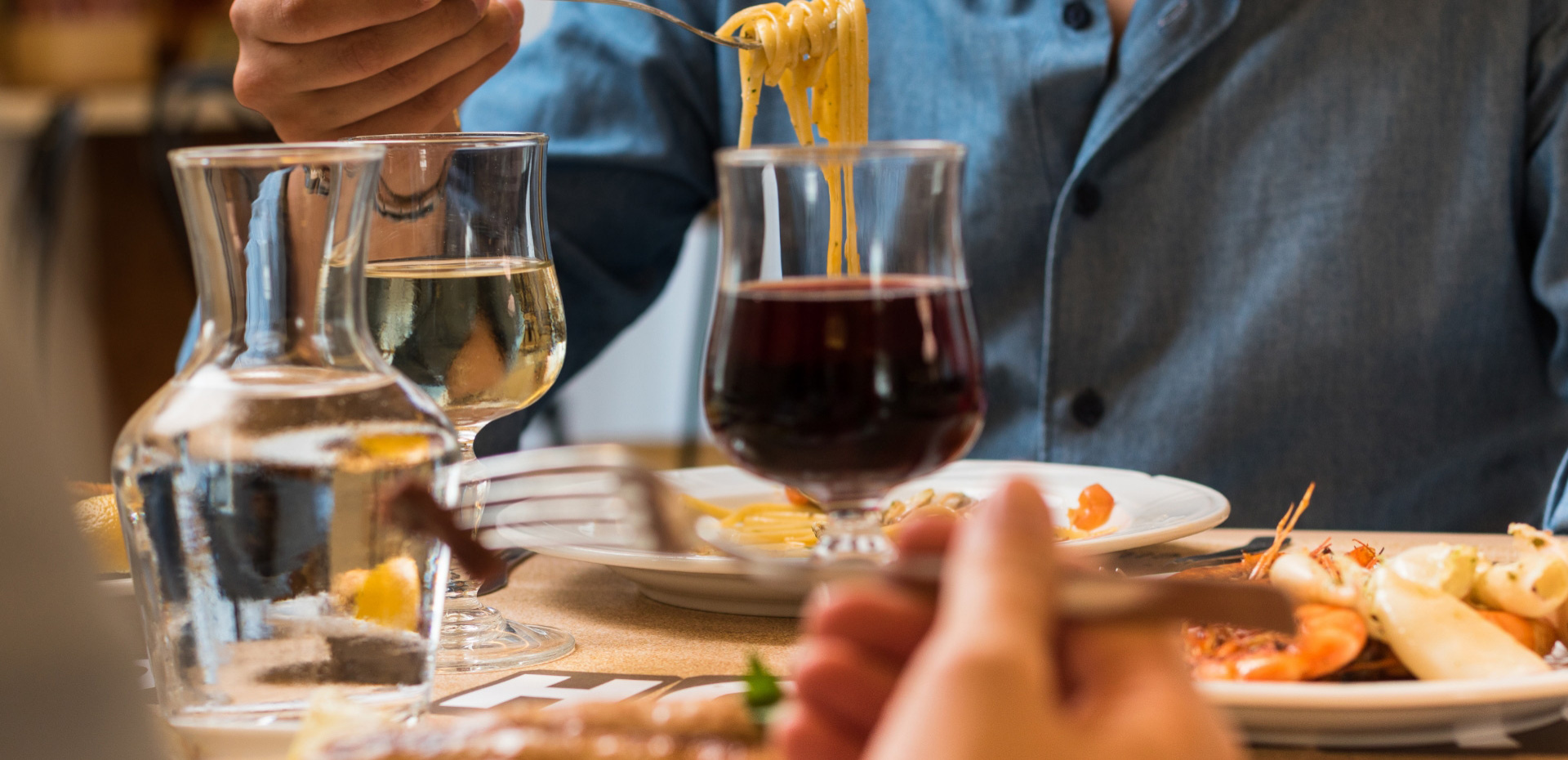 Cena con spaghetti, vino rosso e bianco, e frutti di mare.