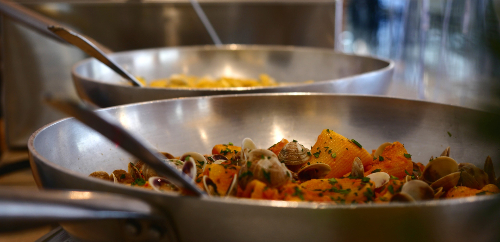 Pasta con vongole e prezzemolo in padella, pronta da servire.