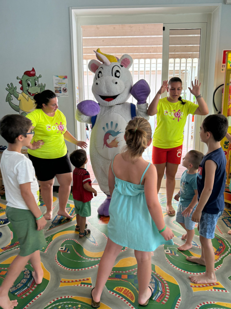 Bambina e donna giocano insieme su un tappeto colorato con giocattoli educativi.