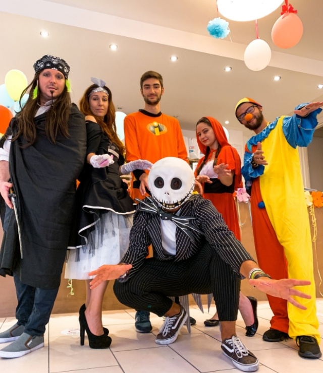 Gruppo in costumi di Halloween, con personaggi famosi e un'atmosfera festosa.
