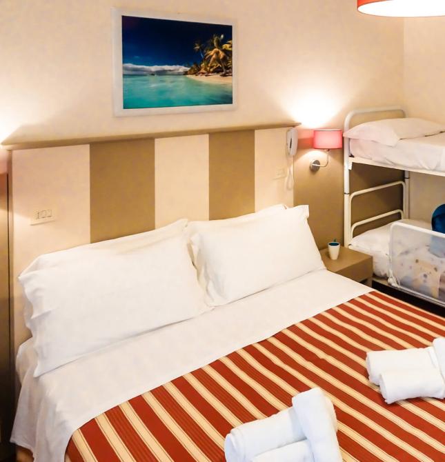Camera con letto matrimoniale e letti a castello, decorata con tema marino.