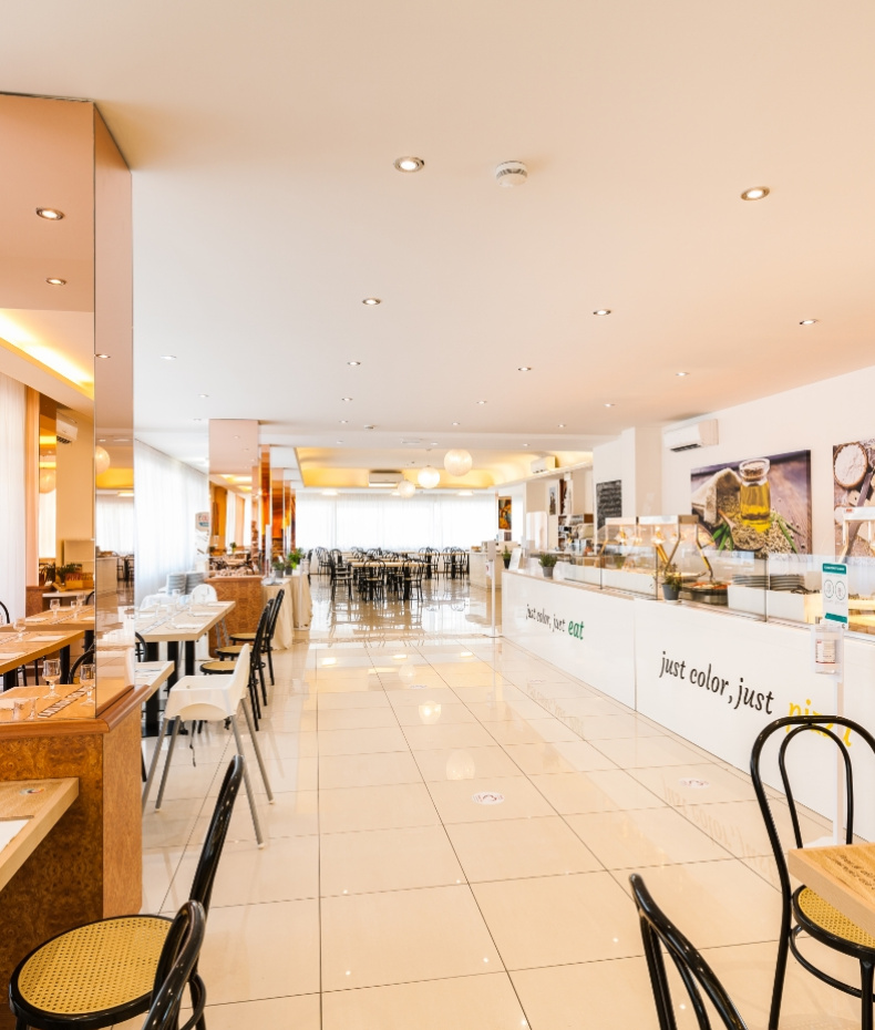 Ristorante luminoso con arredi moderni e ampio spazio per sedersi.